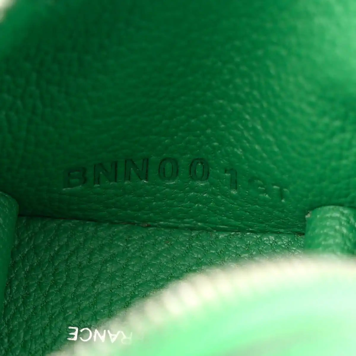 Green leather close-up with 'BAMBOO' stamped on bag charm interior seam