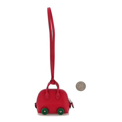 Red leather car bag charm with green wheels and hanging strap