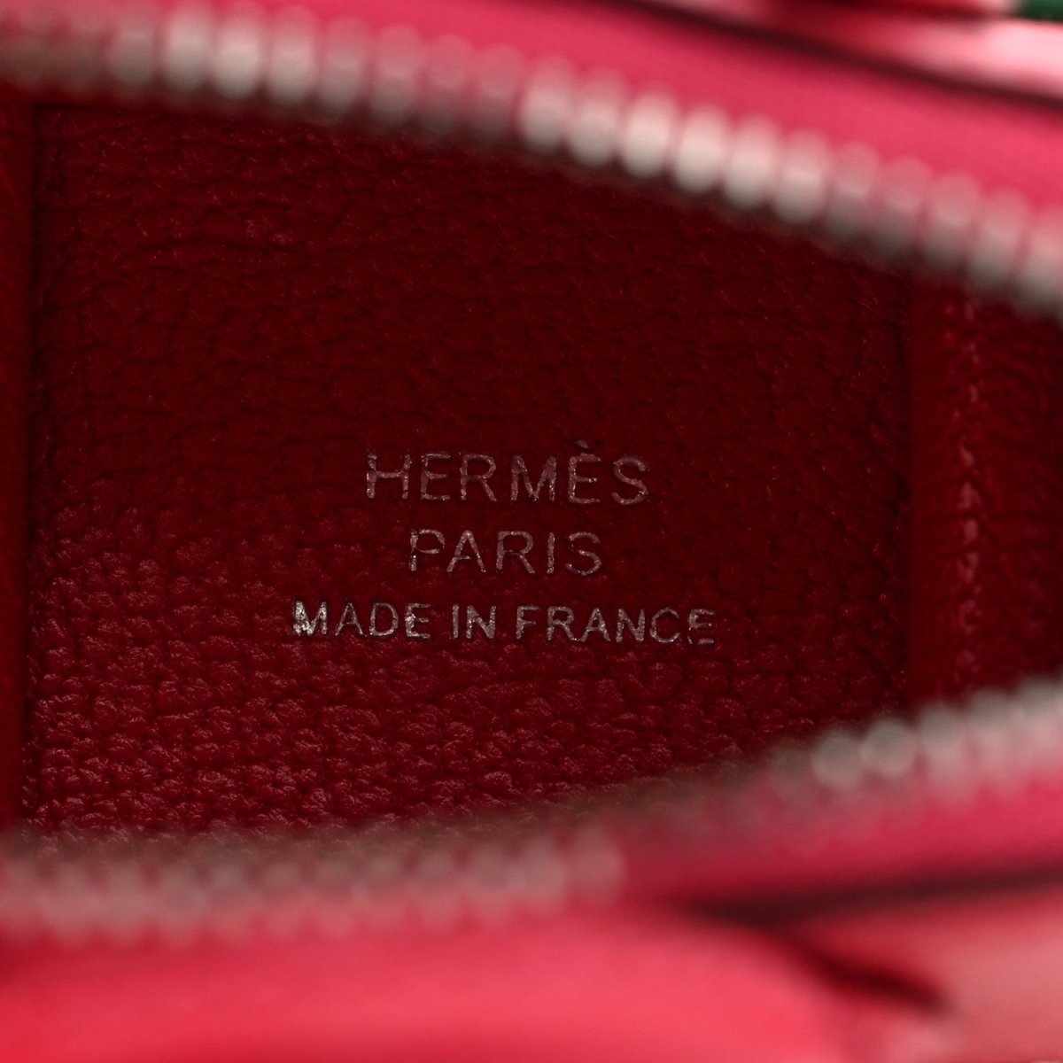 Red leather bag charm close-up showing HERMÈS PARIS MADE IN FRANCE stamp