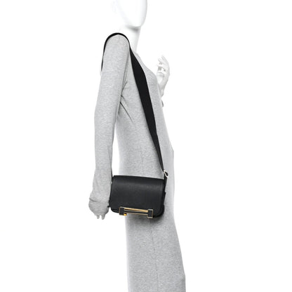 Hermes black leather crossbody bag on model with adjustable shoulder strap