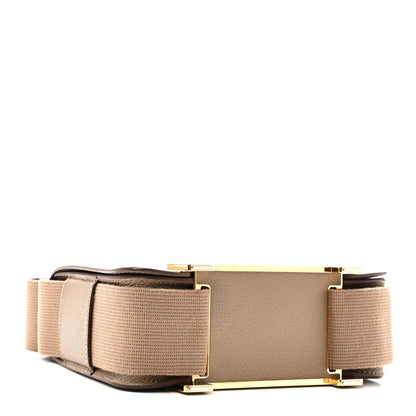 Taupe messenger bag with front flap, wide canvas strap, and gold-tone hardware