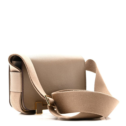 Taupe leather messenger bag with side profile, canvas strap, and gold-tone buckle
