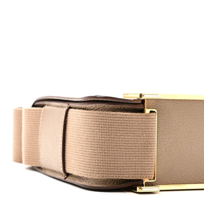 Messenger bag side view with taupe canvas strap and gold-tone buckle hardware