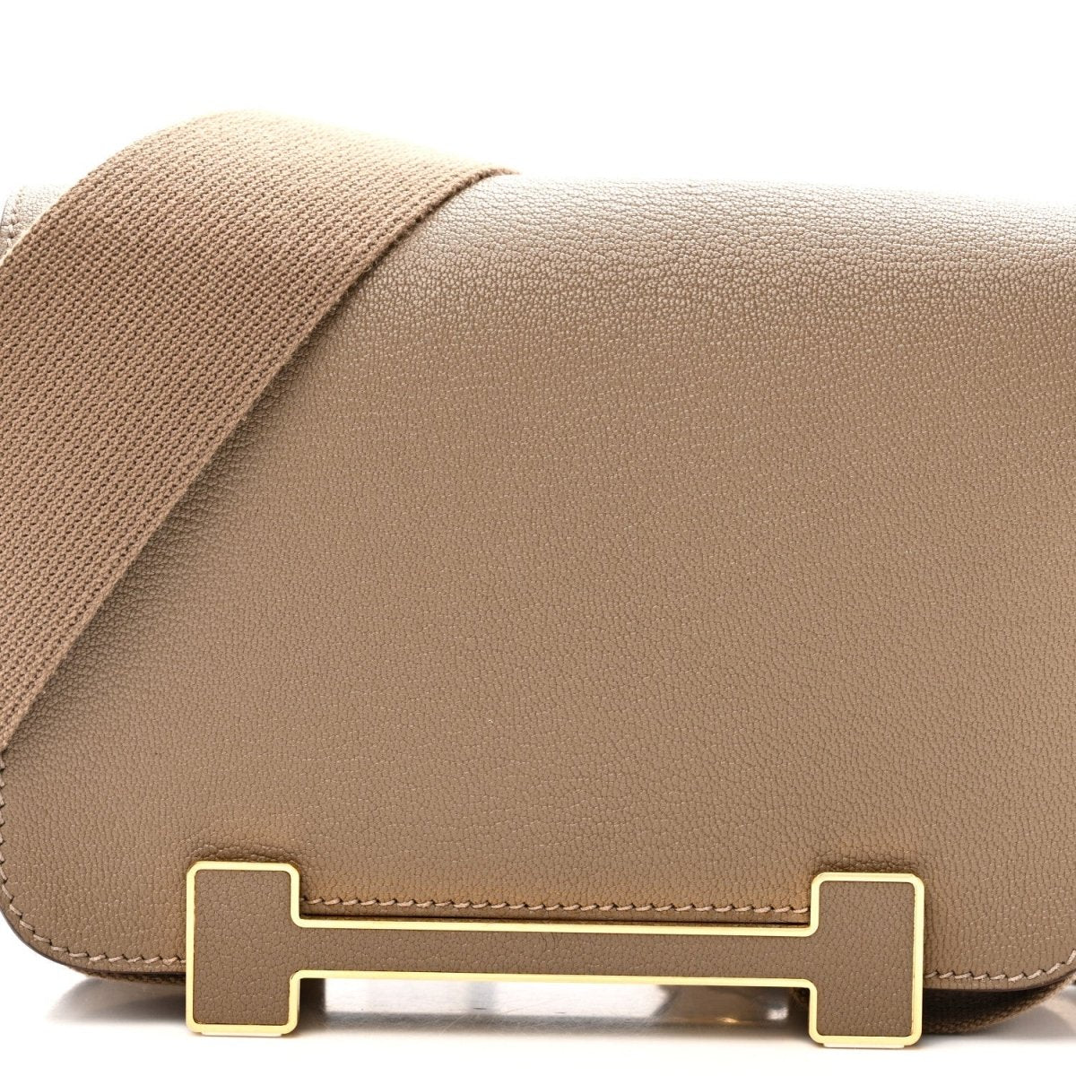 Front flap of taupe leather messenger bag with gold-tone turn-lock hardware