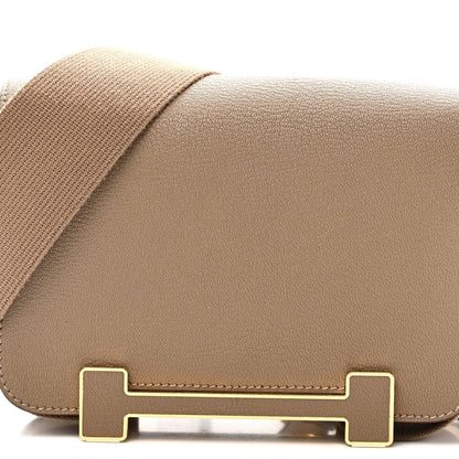 Front flap of taupe leather messenger bag with gold-tone turn-lock hardware