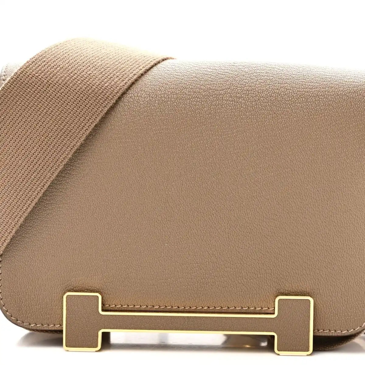 Front flap of taupe leather messenger bag with gold-tone turn-lock hardware