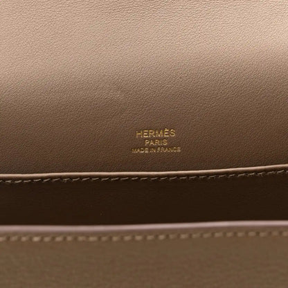 Taupe leather bag panel with embossed brand text and contrast edge stitching