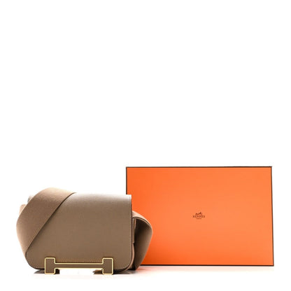Hermes taupe leather messenger bag with front flap and gold buckle, adjustable strap