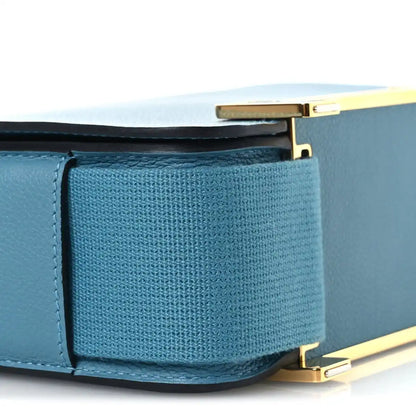 Blue leather messenger bag close-up of interior pocket under open flap and gold hardware.