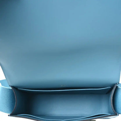 Blue leather bag interior with flap opening and stitched lining edge.