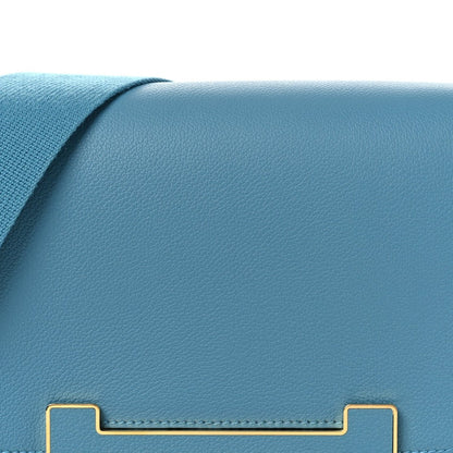 Blue leather flap front with gold-tone clasp rails and stitched edging.