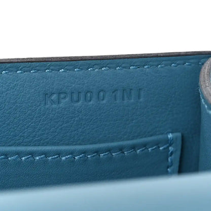 Blue leather bag with embossed code and visible stitched seam detail.