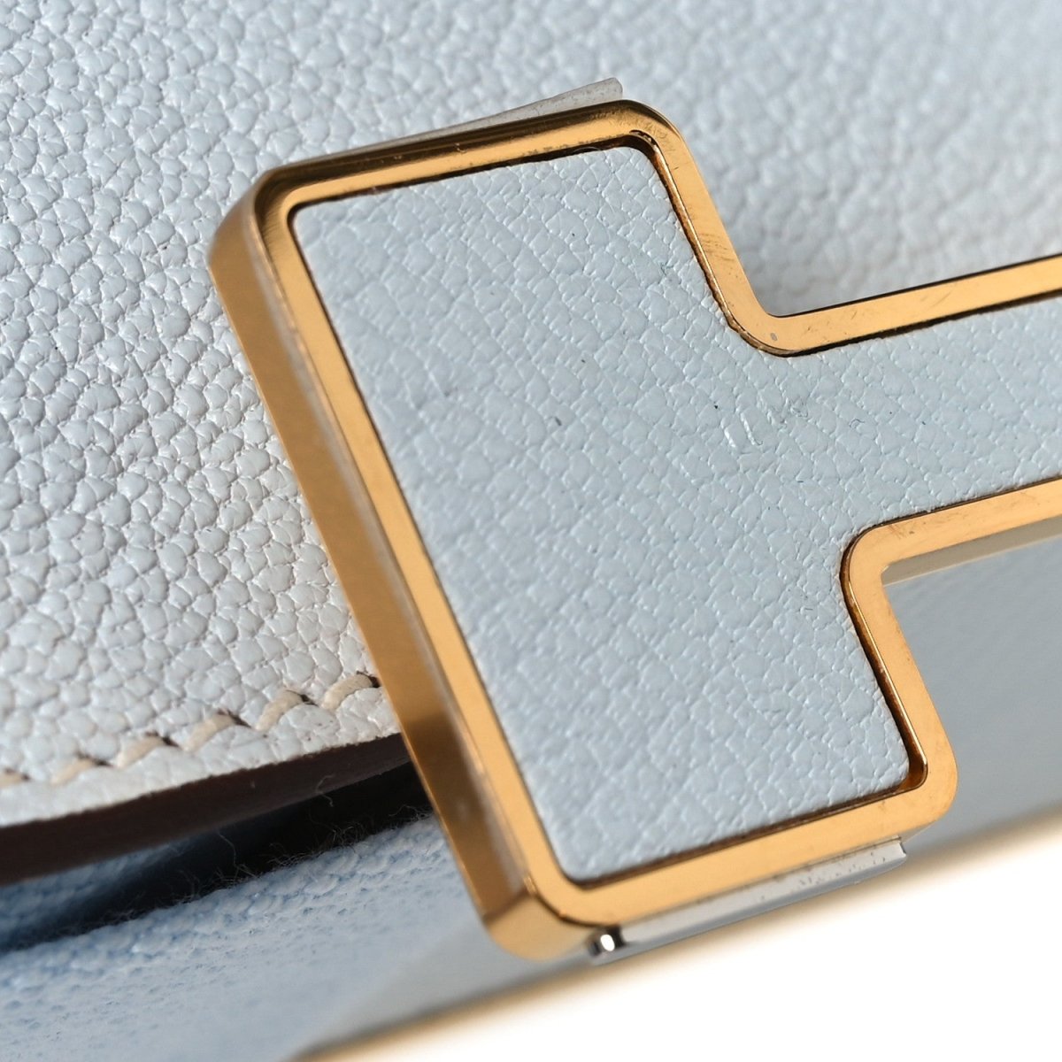 Leather crossbody bag with flap, gold-tone trim, textured light blue exterior corner