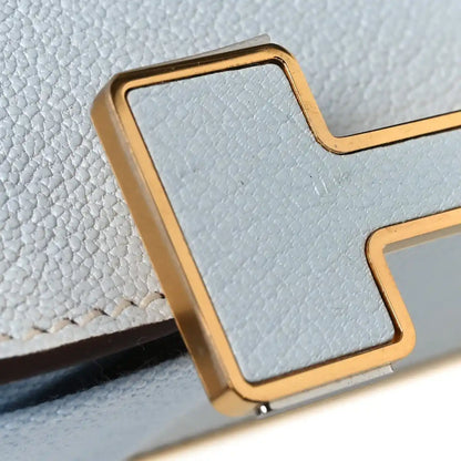 Leather crossbody bag with flap, gold-tone trim, textured light blue exterior corner