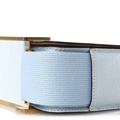 Light blue leather crossbody bag corner with gold-tone hardware and stitching