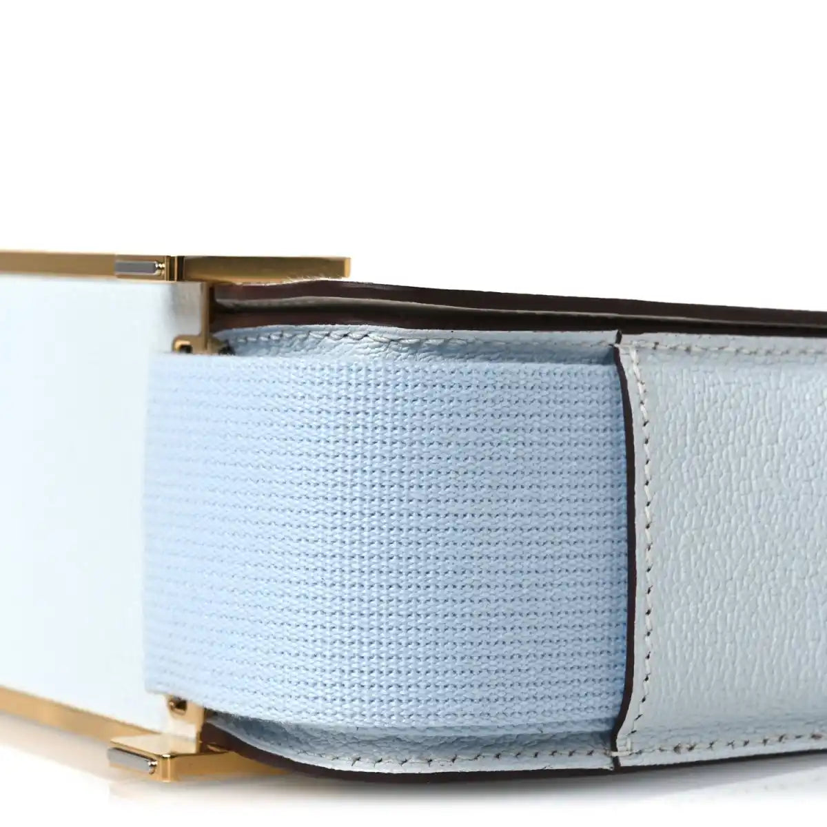 Light blue leather crossbody bag corner with gold-tone hardware and stitching