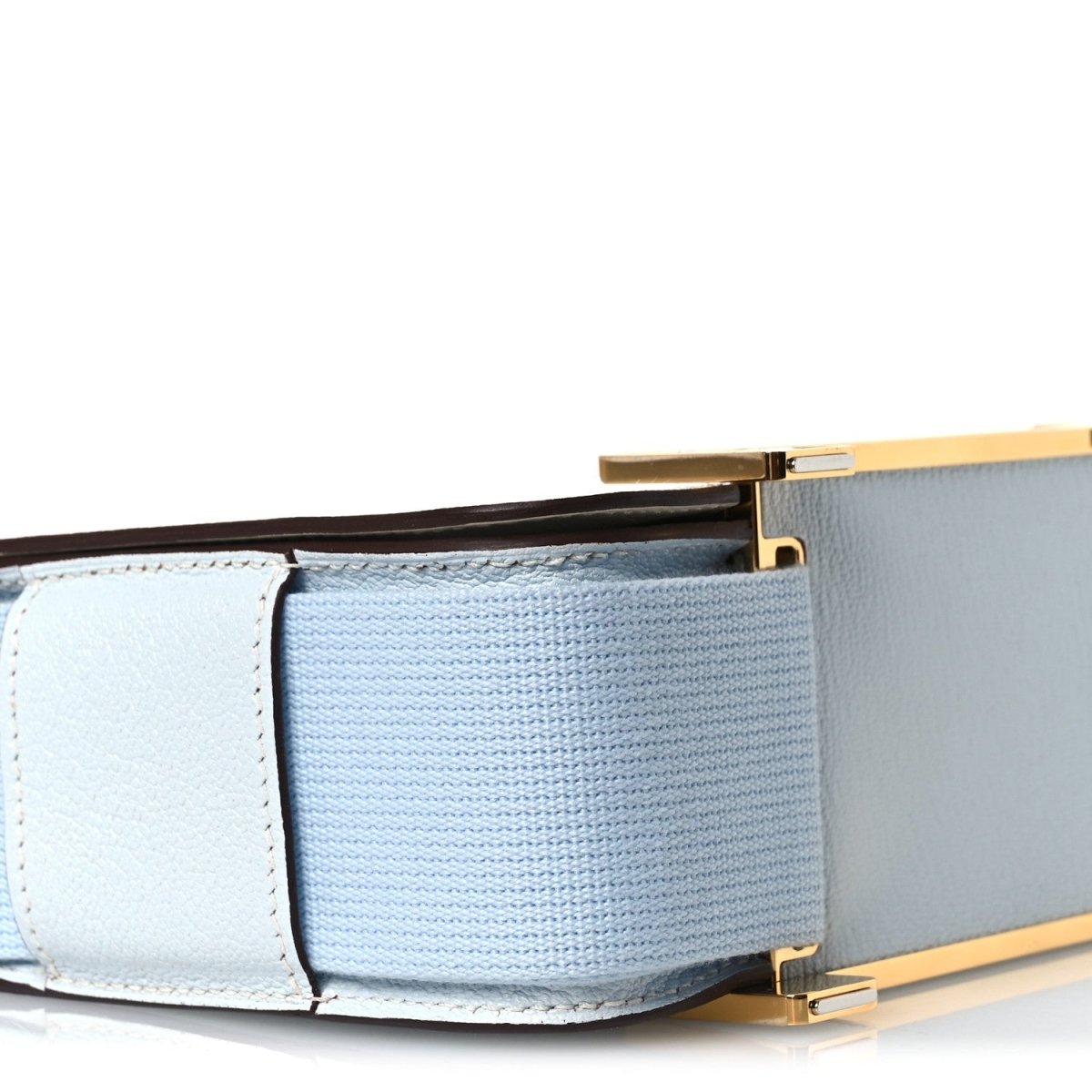 Light blue crossbody bag underside with gold-tone clasp and strap tab