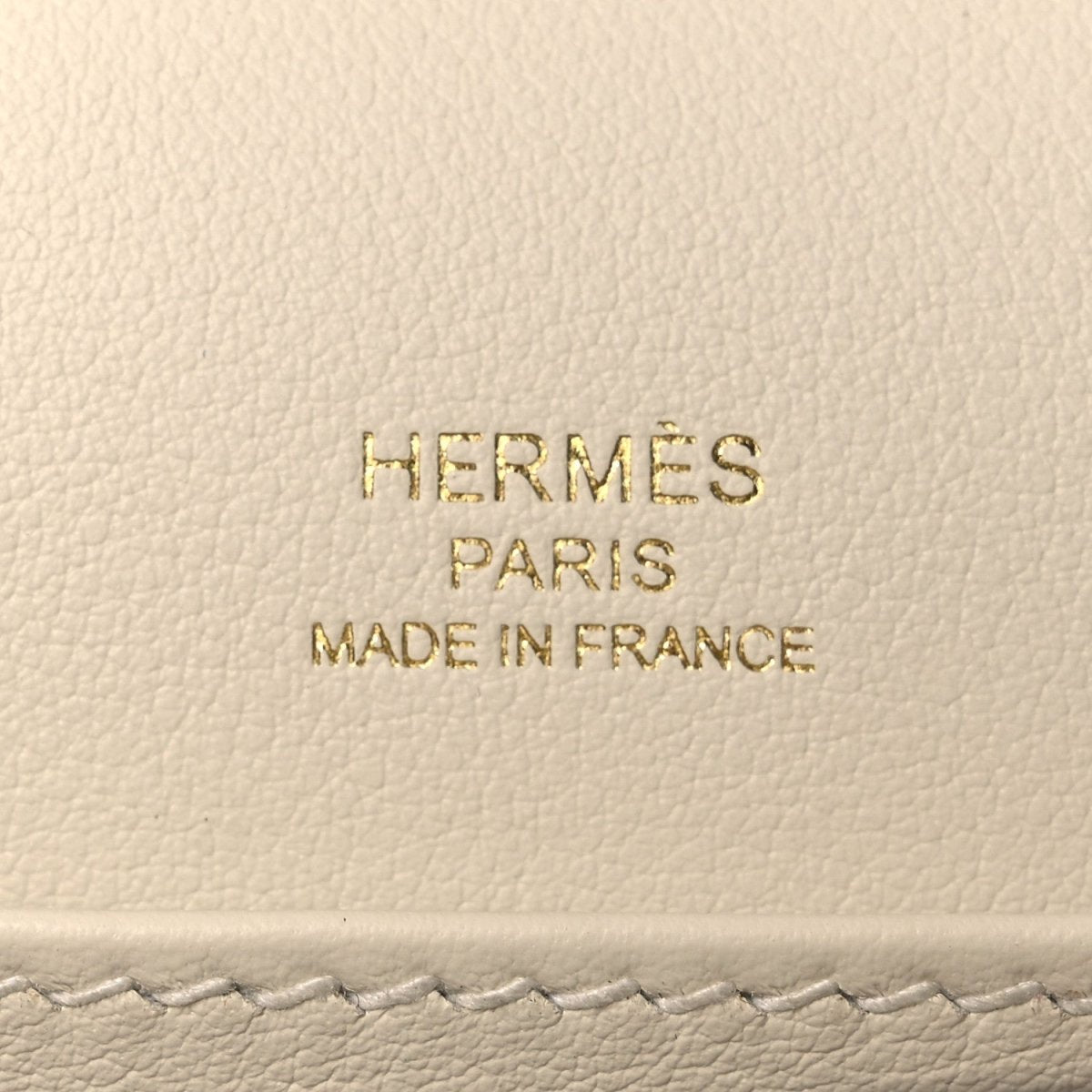 Embossed text on light leather: HERMÈS PARIS MADE IN FRANCE