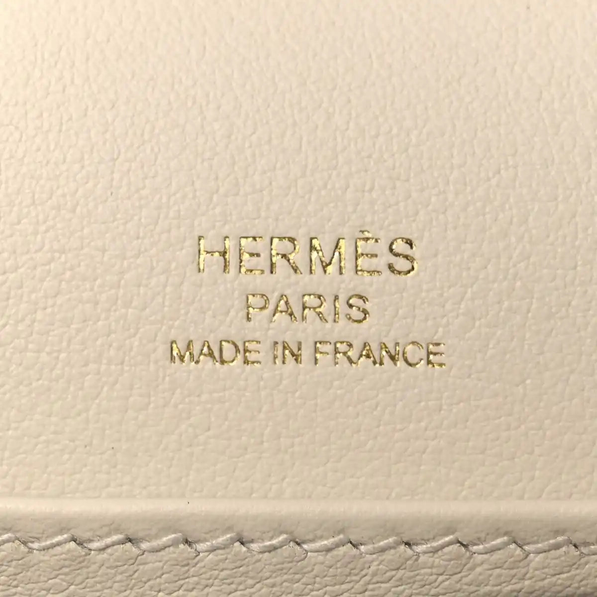 Embossed text on light leather: HERMÈS PARIS MADE IN FRANCE
