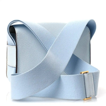 Light blue leather crossbody bag with wide strap and gold-tone clasp