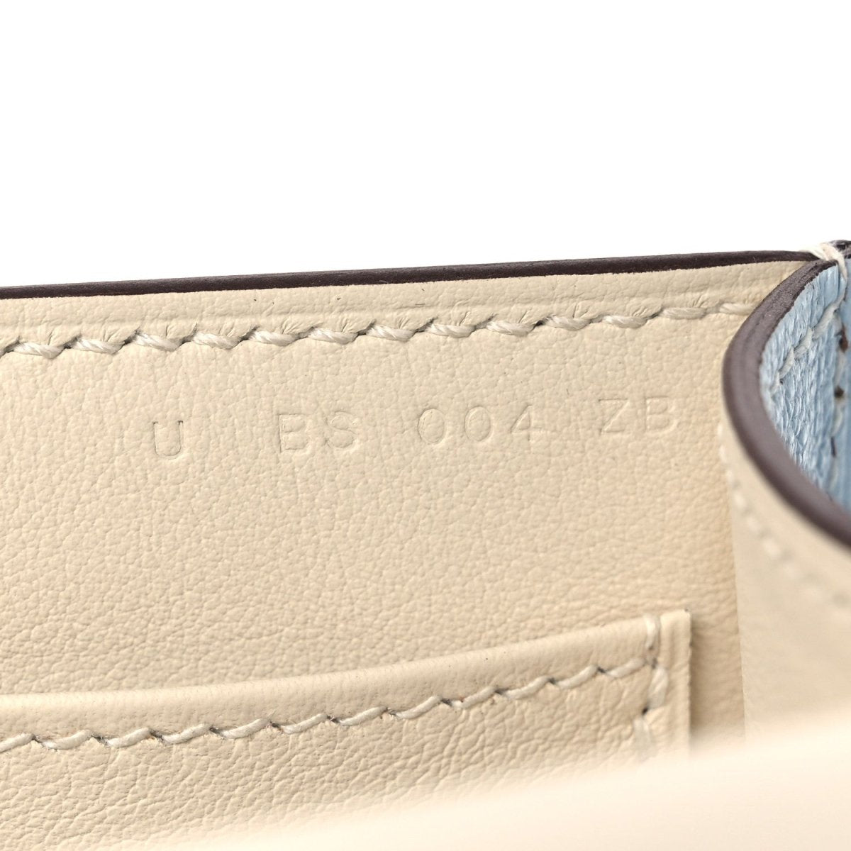 Light blue leather interior panel with stitched edge and embossed marks