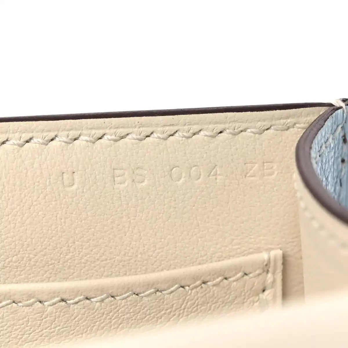 Light blue leather interior panel with stitched edge and embossed marks