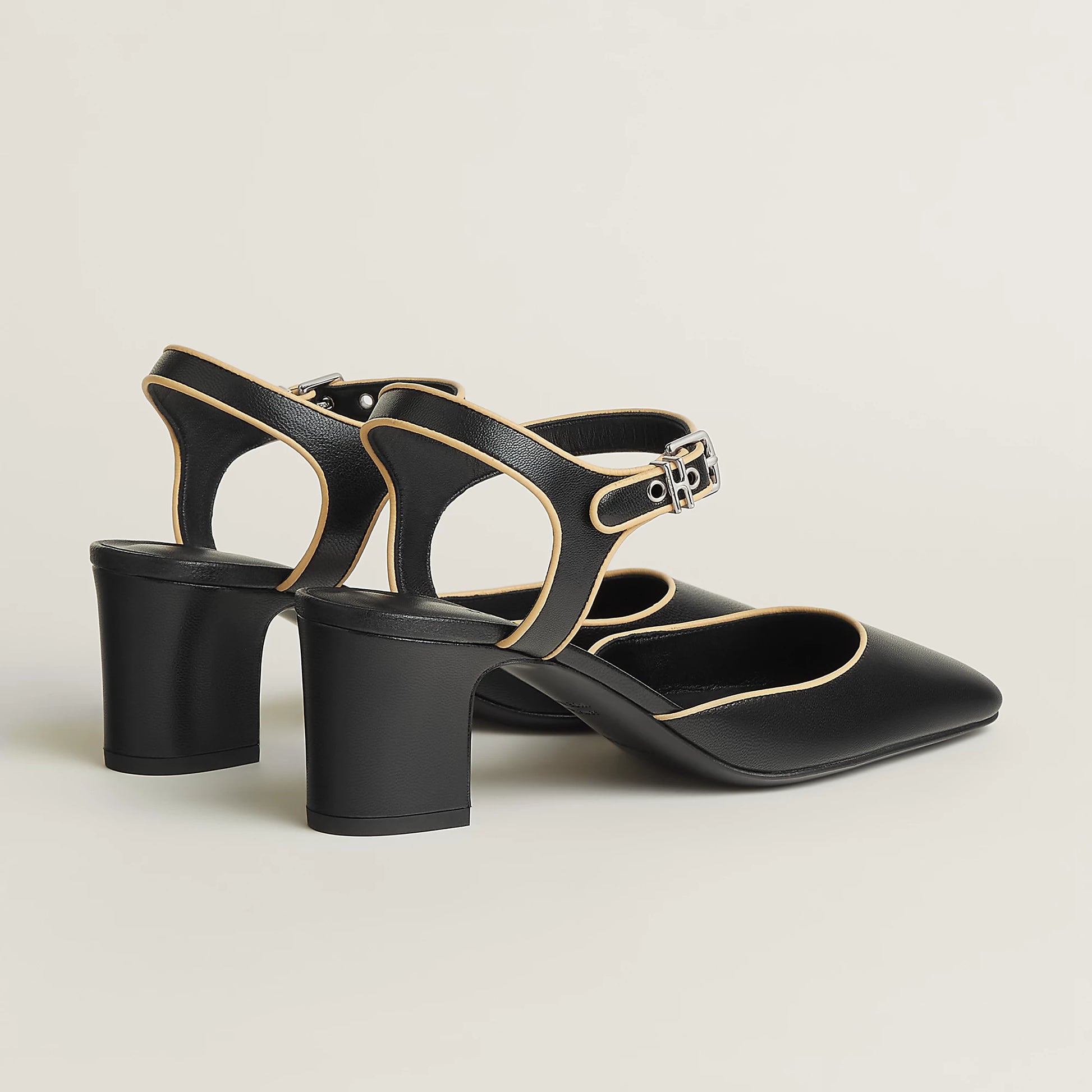 Black Mary Jane pump with ankle strap and gold buckle, cutout vamp, block heel.