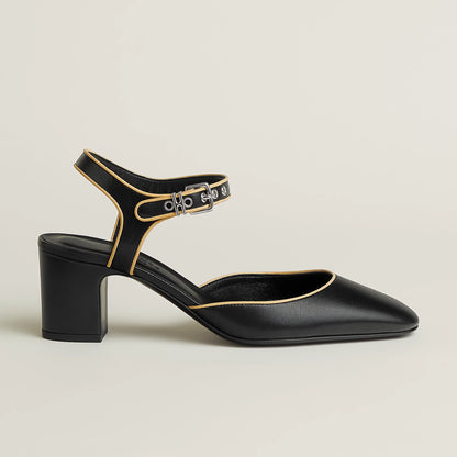 Black Mary Jane pump showing ankle strap and gold buckle, block heel, pointed toe.