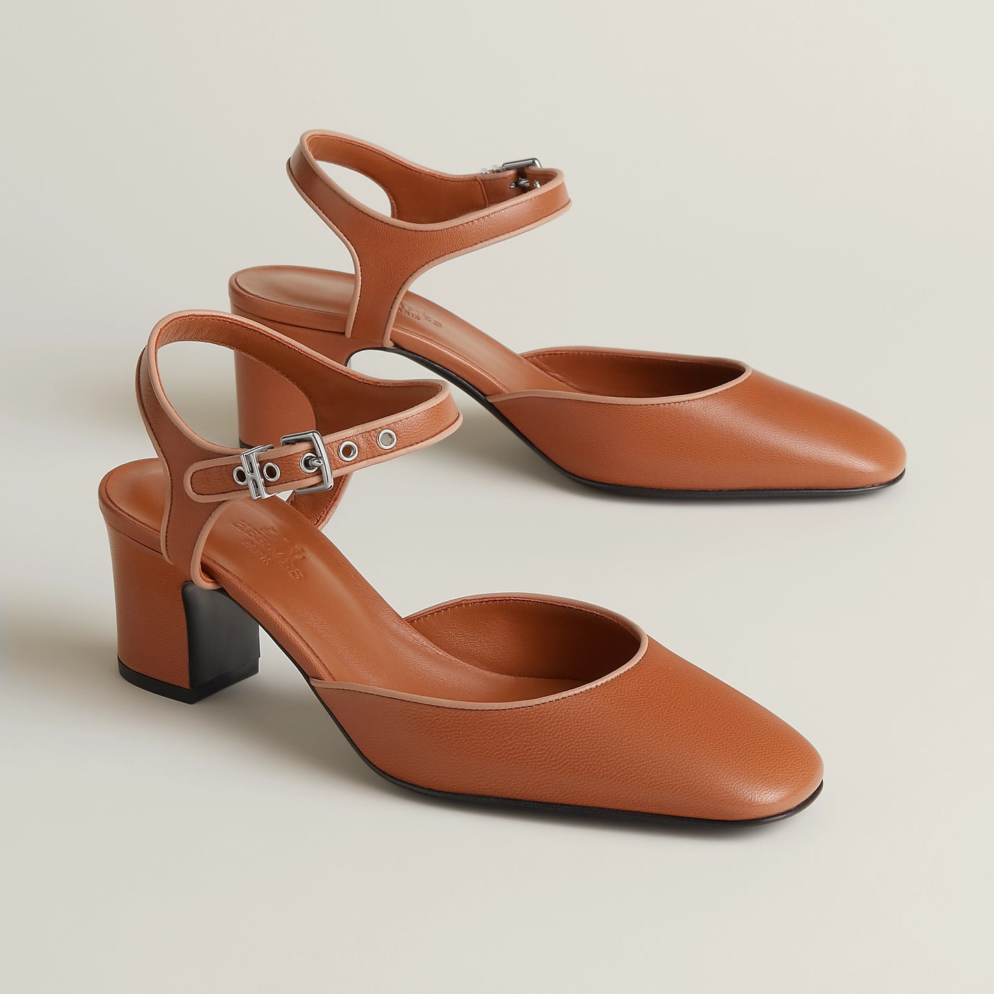 Brown Mary Jane pump pair with ankle straps, silver buckles, block heel, pointed toe.