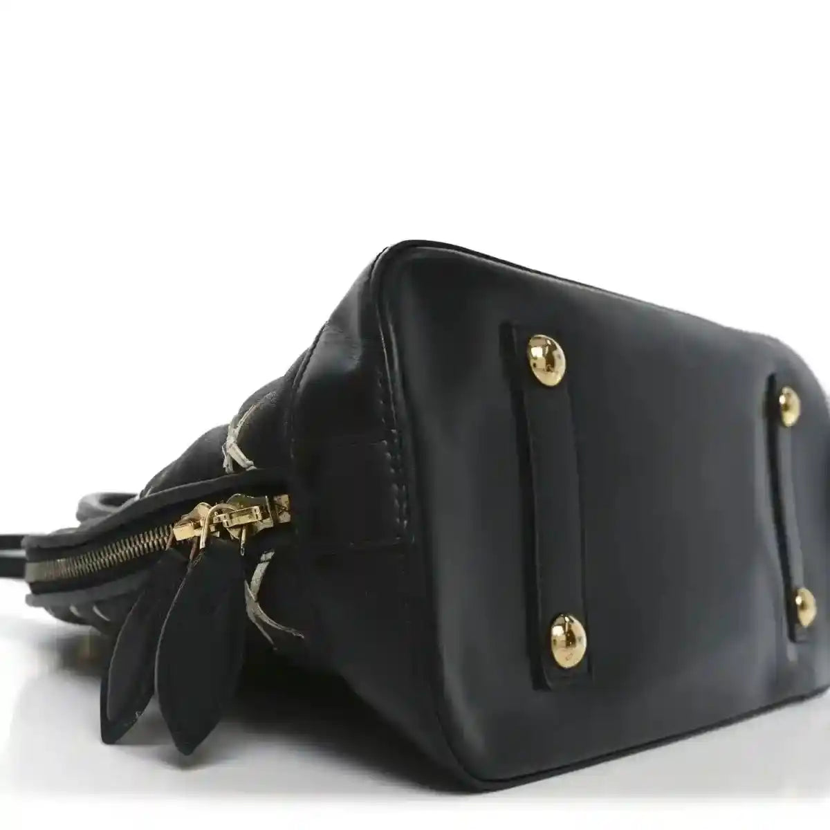 Black leather handbag side view with gold-tone studs and short strap
