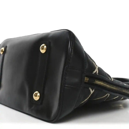 Black handbag corner with gold-tone studs and top zipper