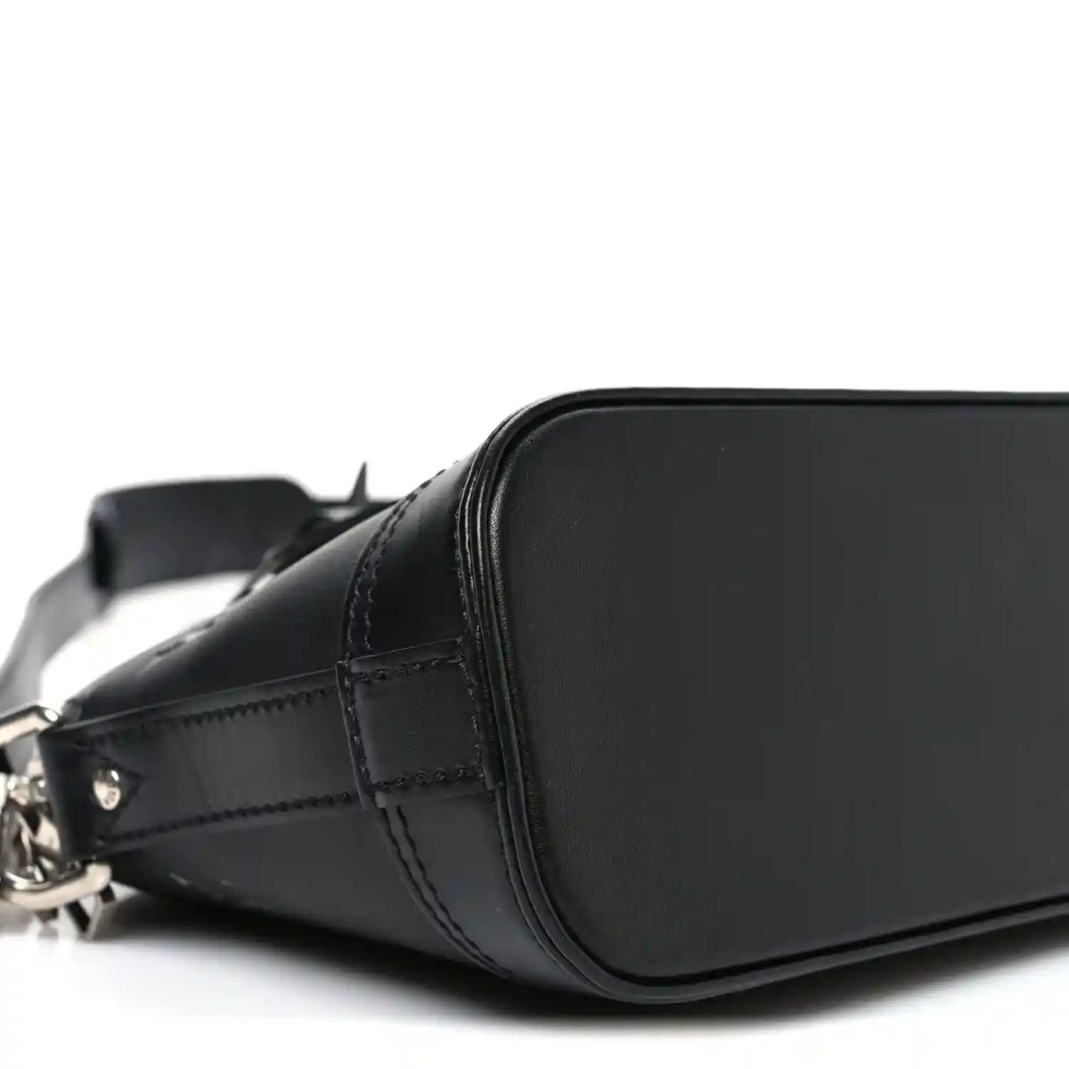 Black Louis Vuitton Alma monogram handbag front curve with stitched leather panel
