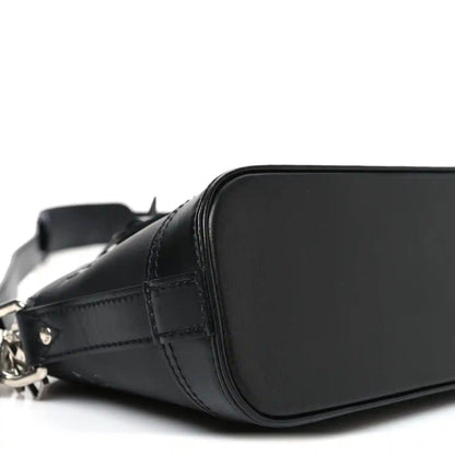 Black Louis Vuitton Alma monogram handbag front curve with stitched leather panel