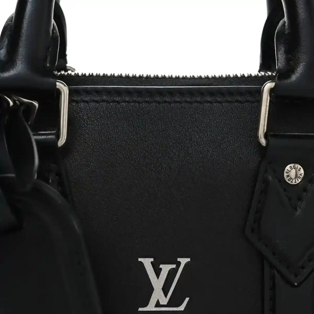 Black Louis Vuitton Alma monogram handbag detail with LV emblem and metal strap loops