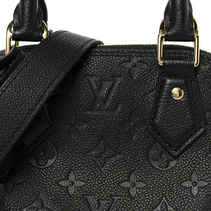Black embossed monogram leather panel with stitched edges near handle