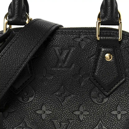 Black embossed monogram leather panel with stitched edges near handle