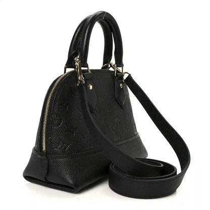 Black leather mini handbag with zip top, dual handles, and crossbody strap