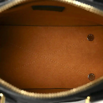 Leather handbag interior with tan lining, stitched seams, and button snap