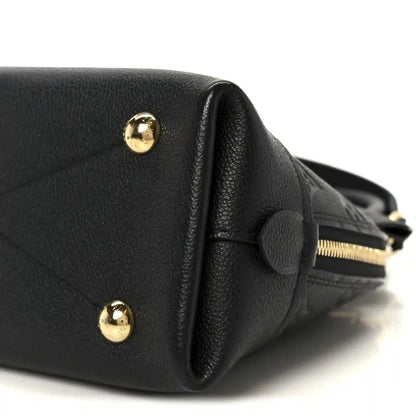 Black leather handbag end with gold-tone studs and fabric strap loop
