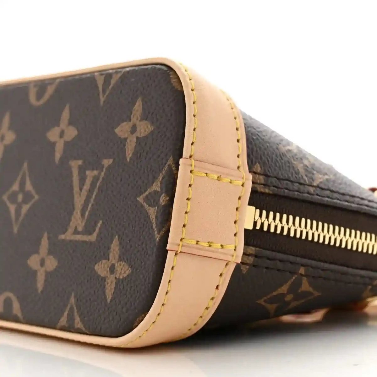 Mini crossbody bag with dark monogram canvas, tan side trim, gold zipper