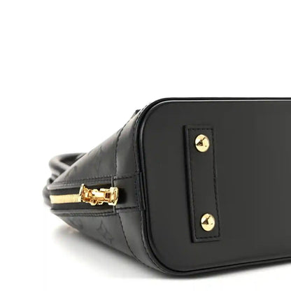 Louis Vuitton Alma BB handbag close-up, black embossed leather with gold logo plaque