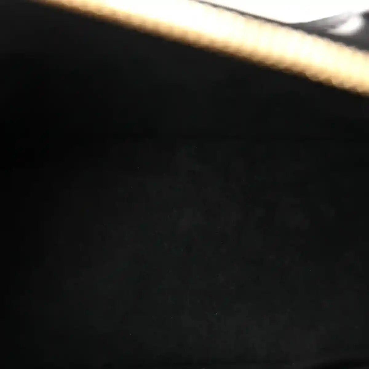 Louis Vuitton Alma BB handbag, close-up of black embossed calfskin texture