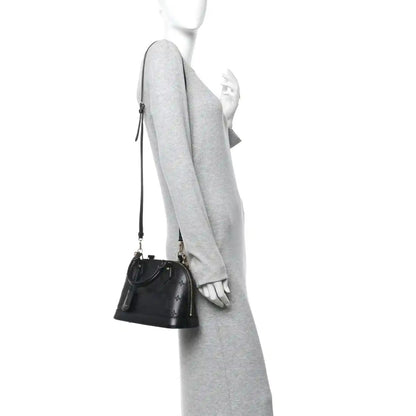 Louis Vuitton Alma BB handbag on model, black embossed leather with slim shoulder strap