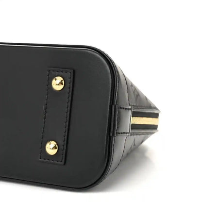 Louis Vuitton Alma BB handbag corner close-up, black leather with gold hardware button