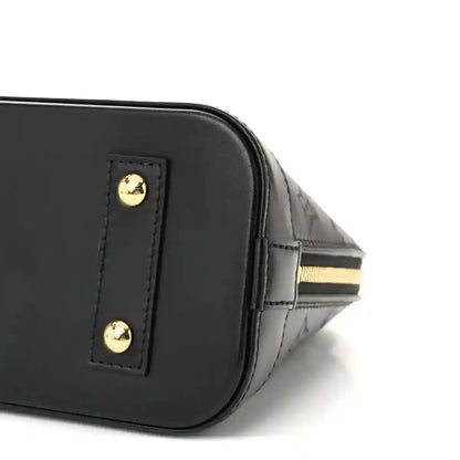 Louis Vuitton Alma BB handbag corner close-up, black leather with gold hardware button