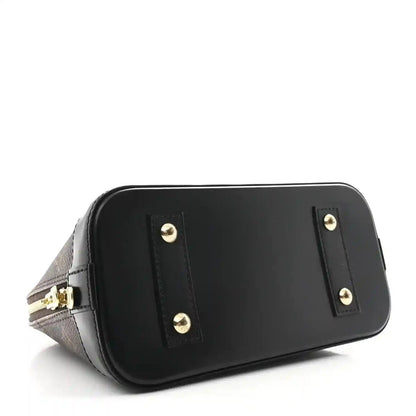 Small monogram tote with black front panel, gold studs, and black leather trim