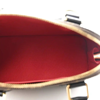 Small monogram tote interior with red lining and visible open top edge