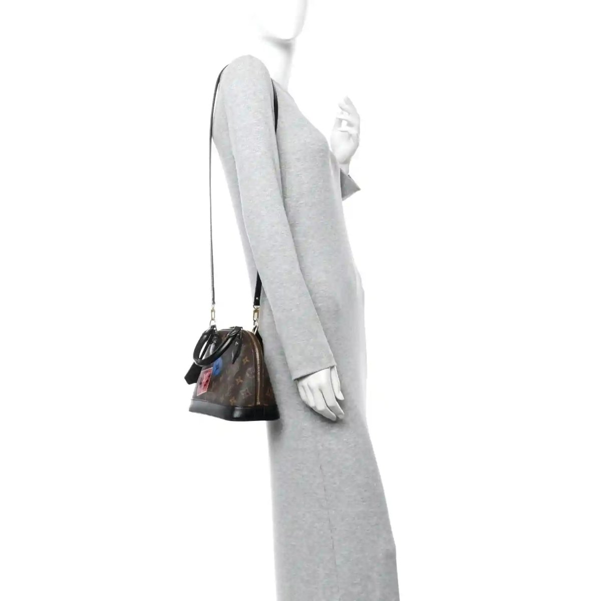 Small monogram tote worn on a person, side view with black strap and top handles