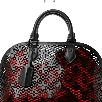 Top view of black lattice monogram handbag with red lining and handles