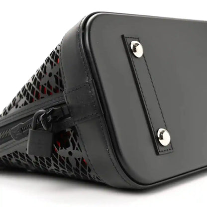 Black leather handbag with monogram cutout side and silver hardware studs